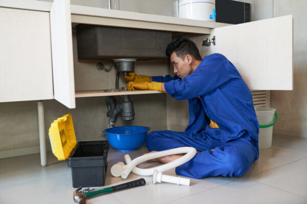 A Plumber fixing sink leakage